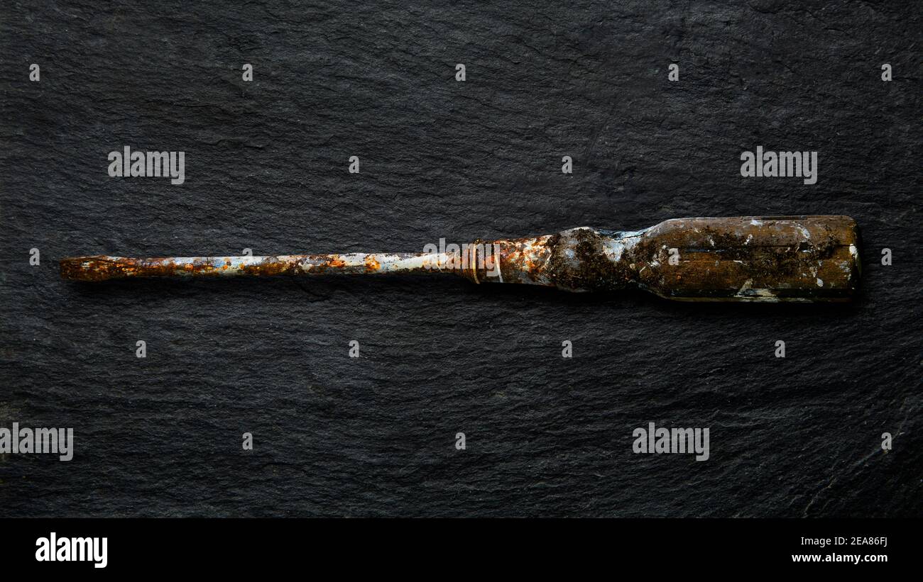 Rusty tool on slate background. Stock Photo
