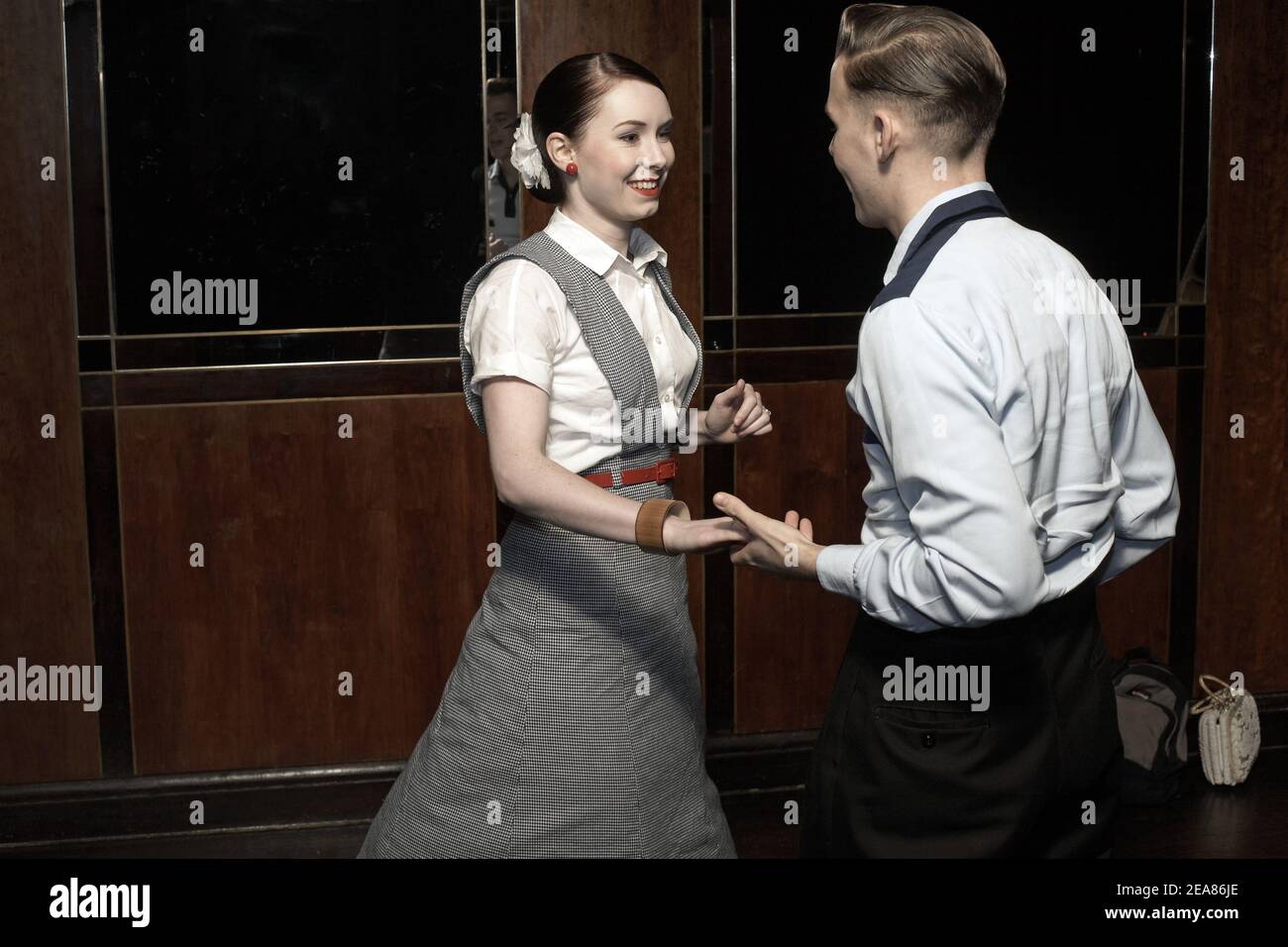 Young couple swing dancing Lindy hopping and jiving to retro 40s 50s music at a club, UK Stock Photo
