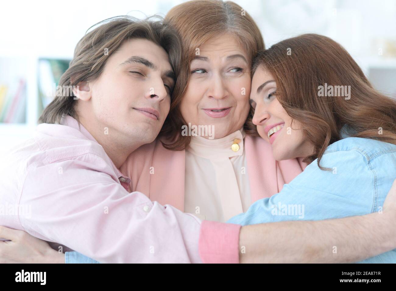 Happy family concept. Adult children hugging their mother Stock Photo