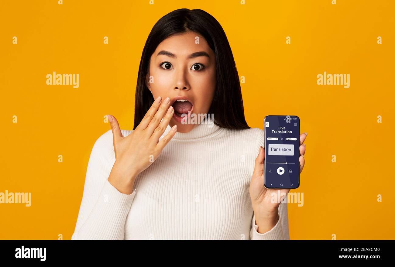 Surprised Asian Woman Holding Smartphone With Opened Voice Translation App On Screen Stock Photo