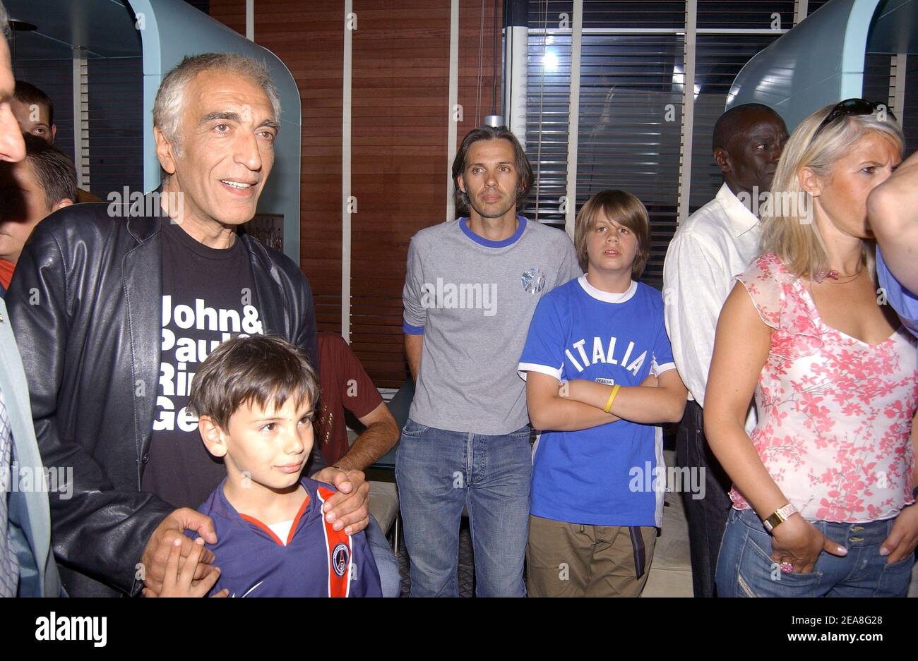 French actor Gerard Darmon (L) and his son, racing team boss Paul Belmondo (C) and his son Alessandro pictured at the party for the presentation of the PSG soccer team's new shirt made by sponsor Nike at the Parc des Princes stadium in Paris-France on June 29, 2004. Photo by Francois-Xavier Lamperti/ABACA. Stock Photo