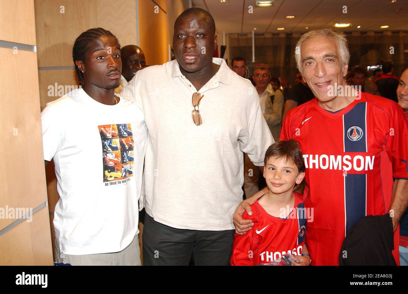 PSG soccer player Bernard Mendy (L), French actors Mouss Diouf (C) and Gerard Darmon with his son pictured at the party for the presentation of the PSG soccer team's new shirt made by sponsor Nike at the Parc des Princes stadium in Paris-France on June 29, 2004. Photo by Bruno Klein/ABACA. Stock Photo