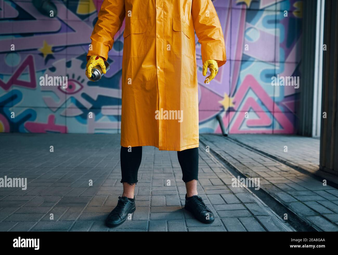 Cropped image of street artist with spray paint can in hand standing ...