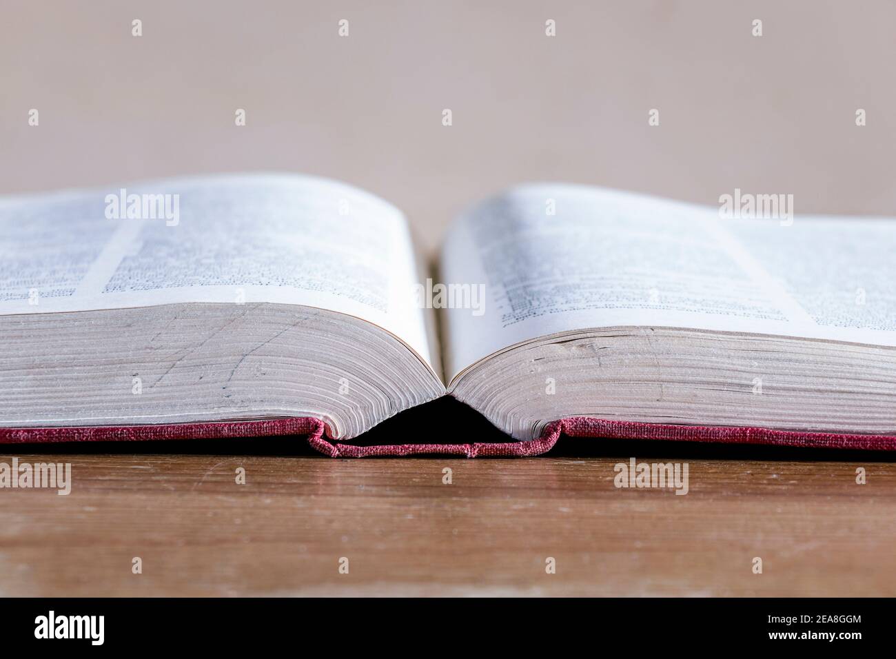 Close-up of an open hardback reference book on an old wooden table Stock Photo