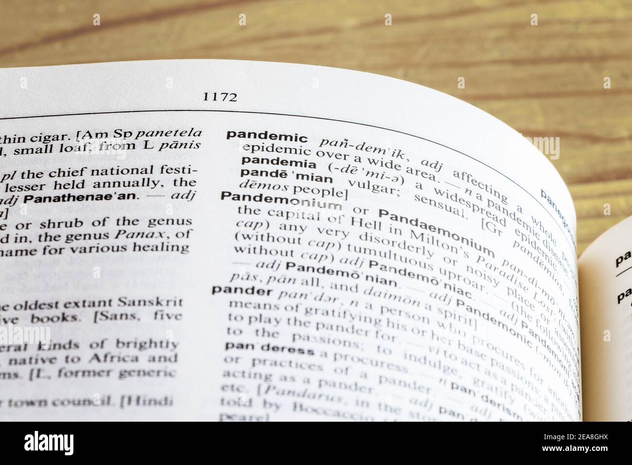 Close-up of Chambers' Dictionary open at the definition of the word 'Pandemic', on an old wooden table Stock Photo