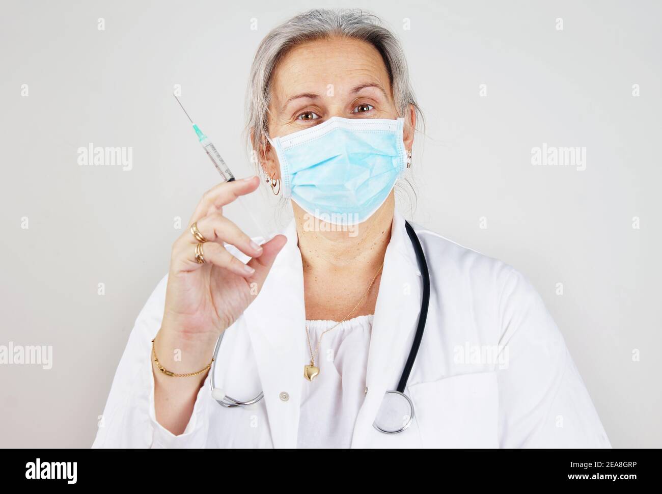 Doctor or nurse with masked and syringe Stock Photo