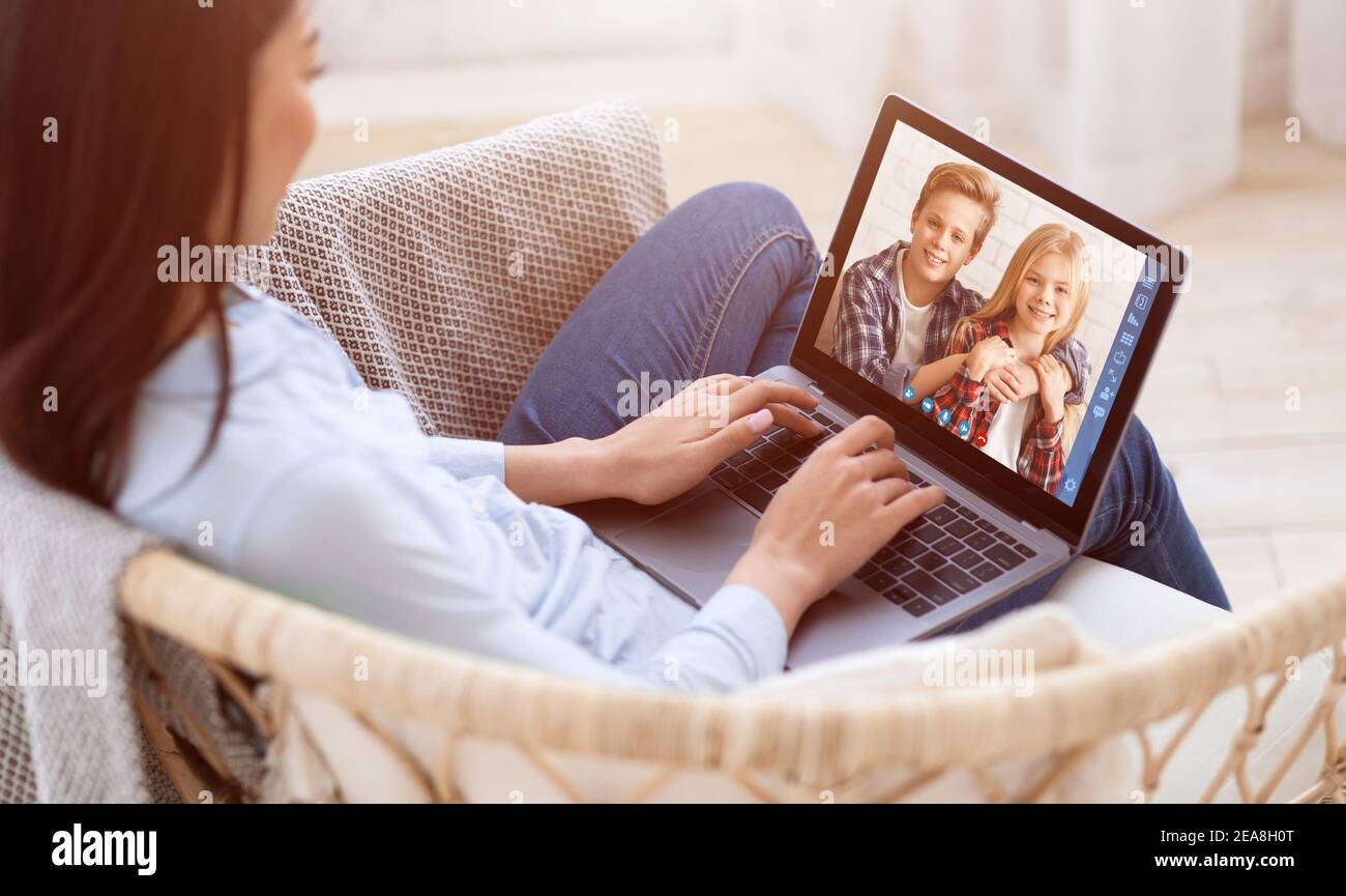 Young mother with laptop talking to her kids online, having video chat with  cute boy and girl on webcam Stock Photo - Alamy