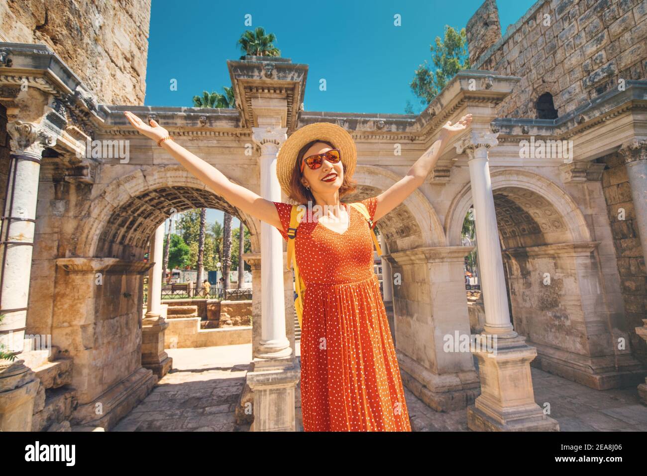 Happy female tourist traveler discover interesting places and popular attractions in the old city of Antalya, Turkey. The famous Roman gate of Hadrian Stock Photo