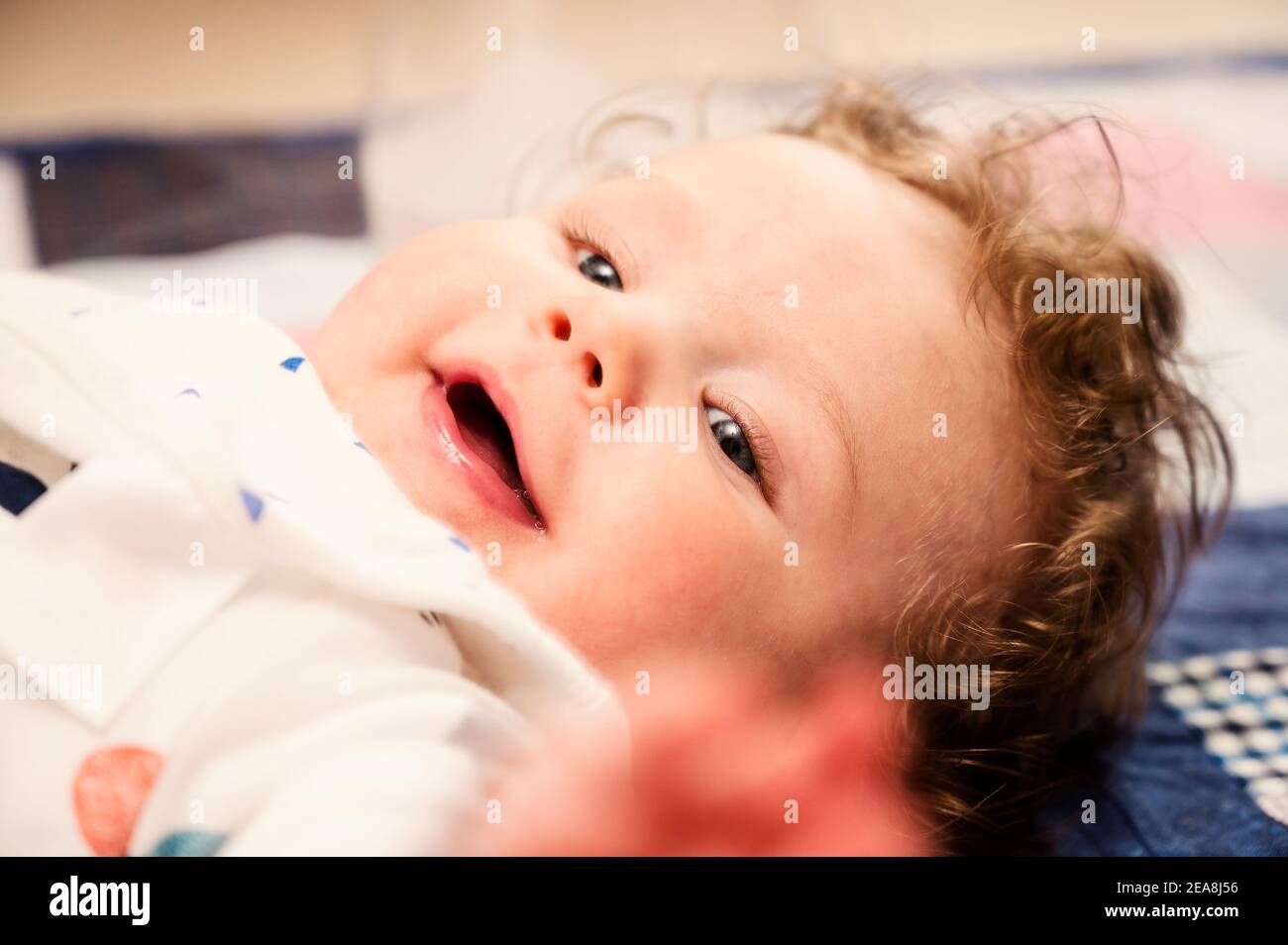 Baby boy lying on back smiling Stock Photo