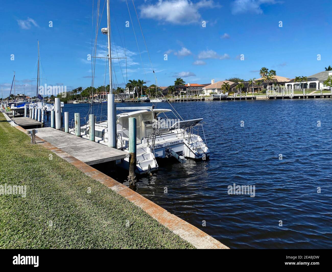 waterway scene, boats, concrete docks, houses, wide canal, marine