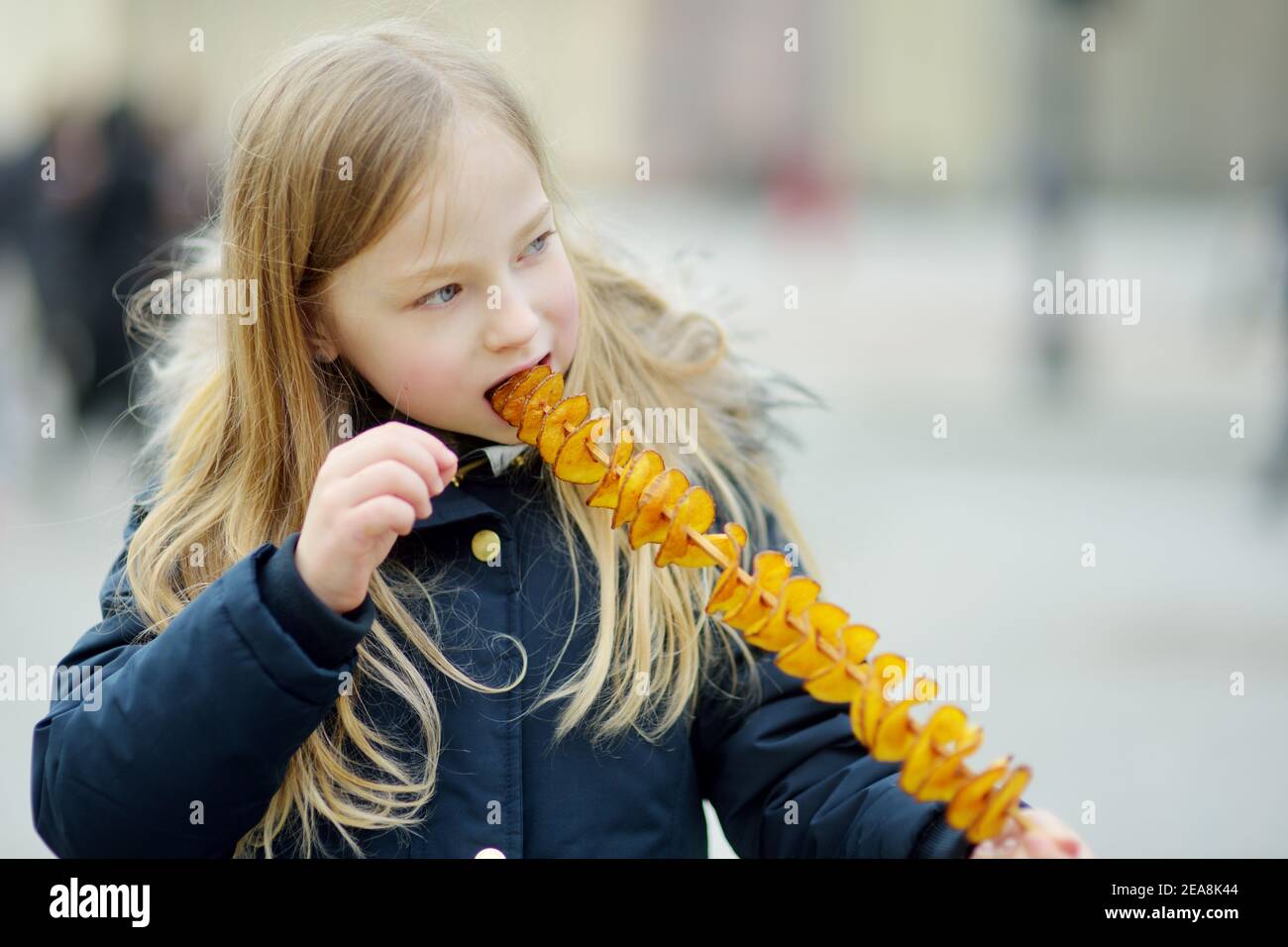 Cute Young Girl Eating Fried Potato On A Stick On Cold Winter Day Outdoors Snacks For Kids Stock Photo Alamy