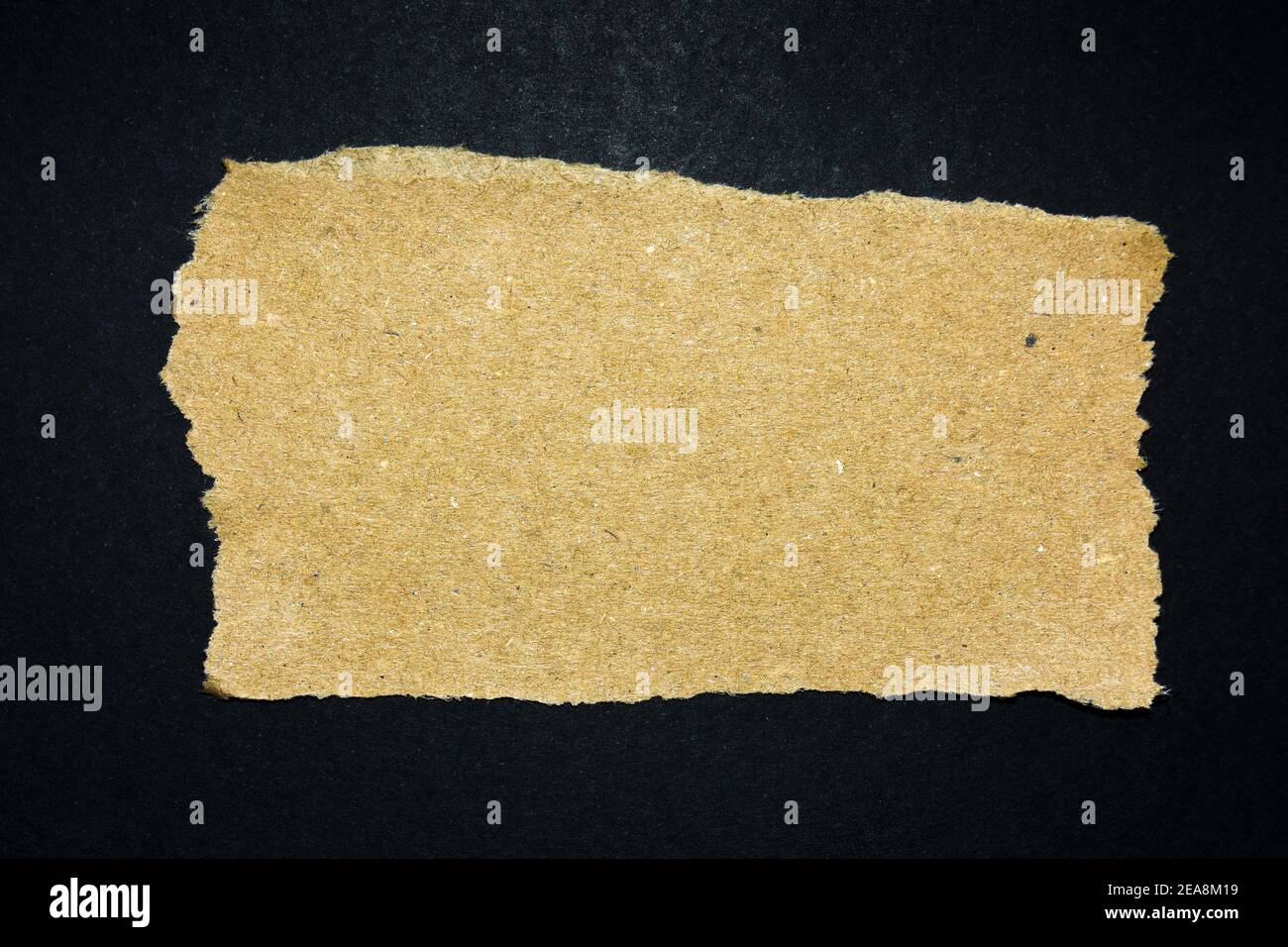 Torn brown paper on a black background, copy space Stock Photo