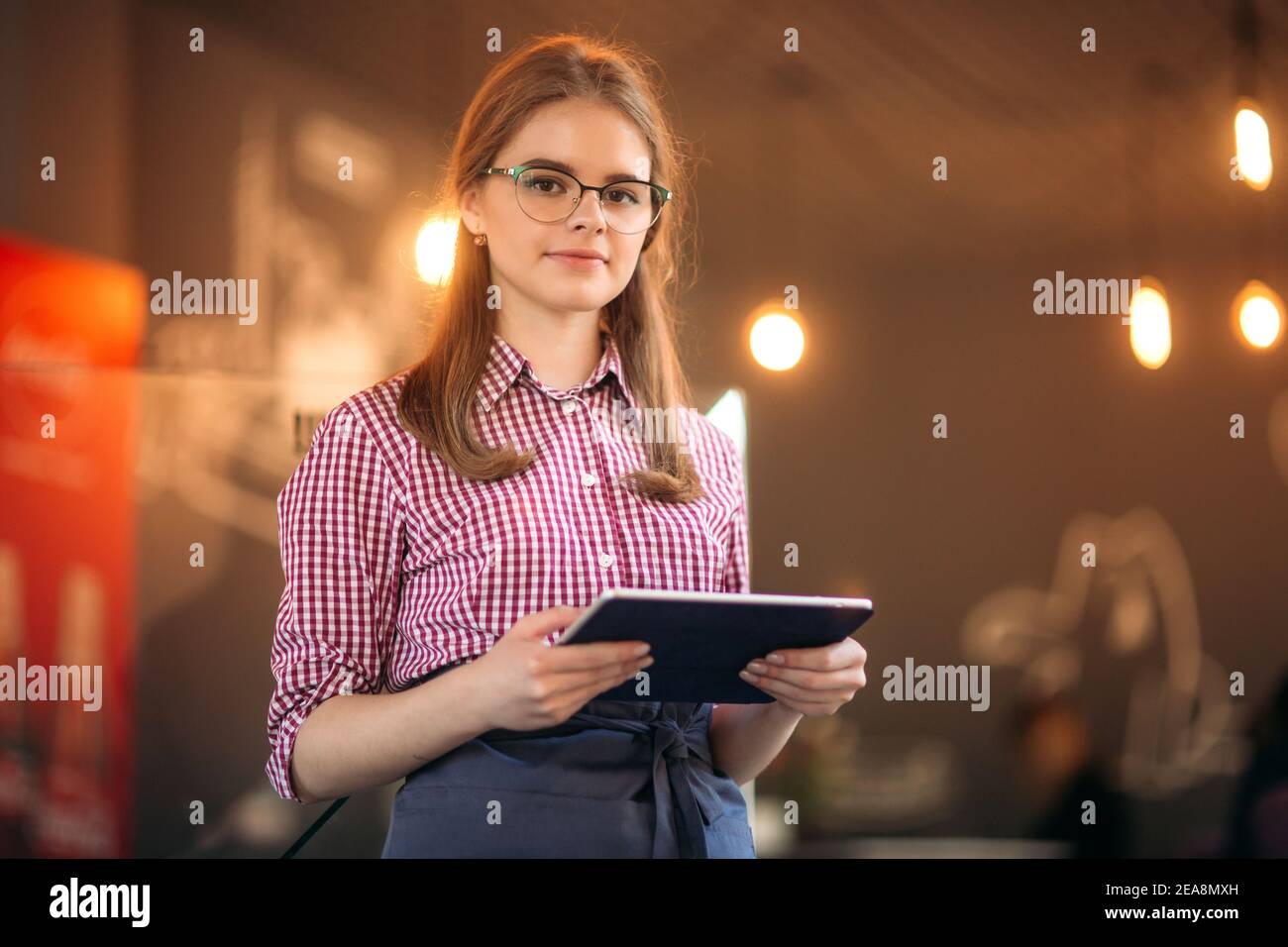 Attractive young waitress using a tablet computer Stock Photo