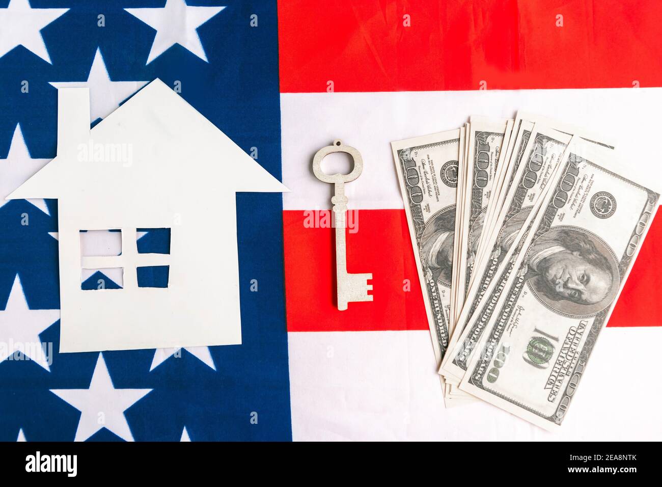 House, key and dollars on American flag background. Realty in America