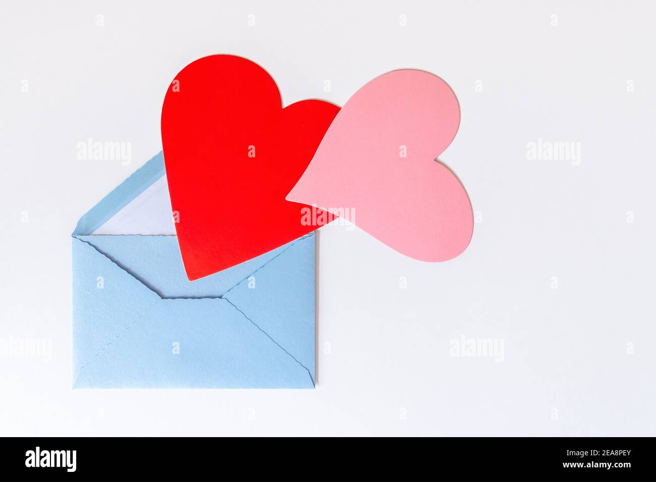 Love letter with hearts. Open blue envelope with big red and pink hearts isolated on white background. Gratitude to doctors and nurses. Valentine's, M Stock Photo