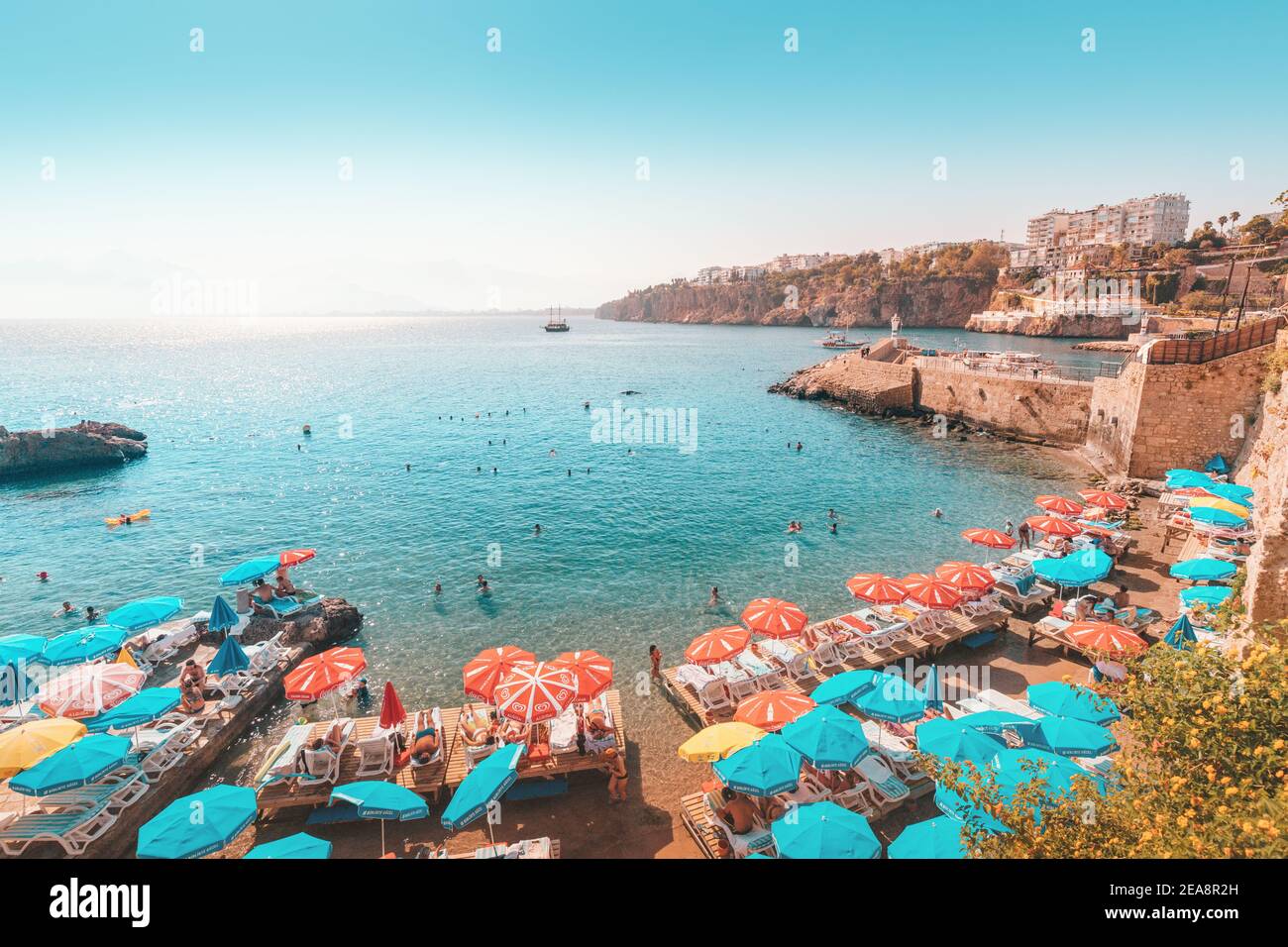 04 September 2020, Mermerli beach, Antalya, Turkey: Sunbeds and umbrellas with resting and sunbathing people in Antalya Stock Photo
