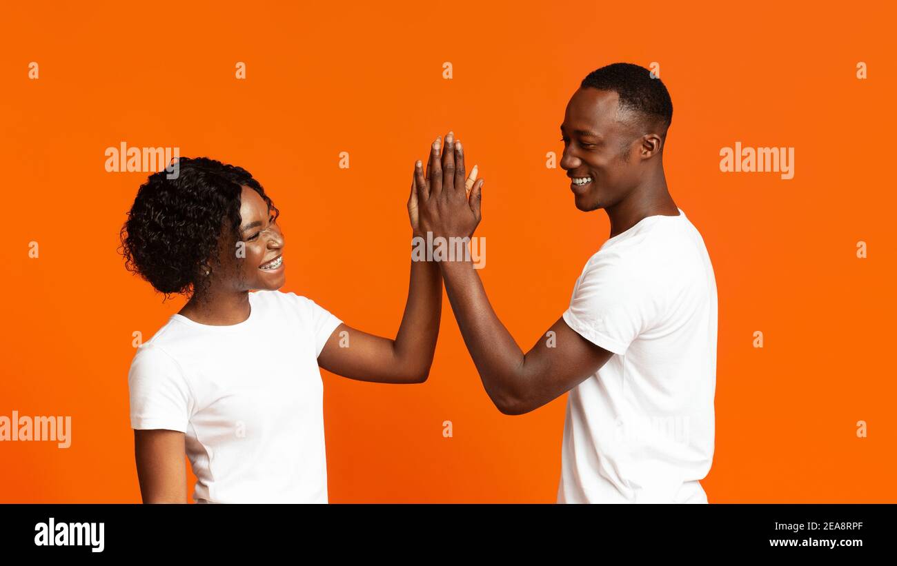 Joyful man and woman greeting each other with high five Stock Photo - Alamy