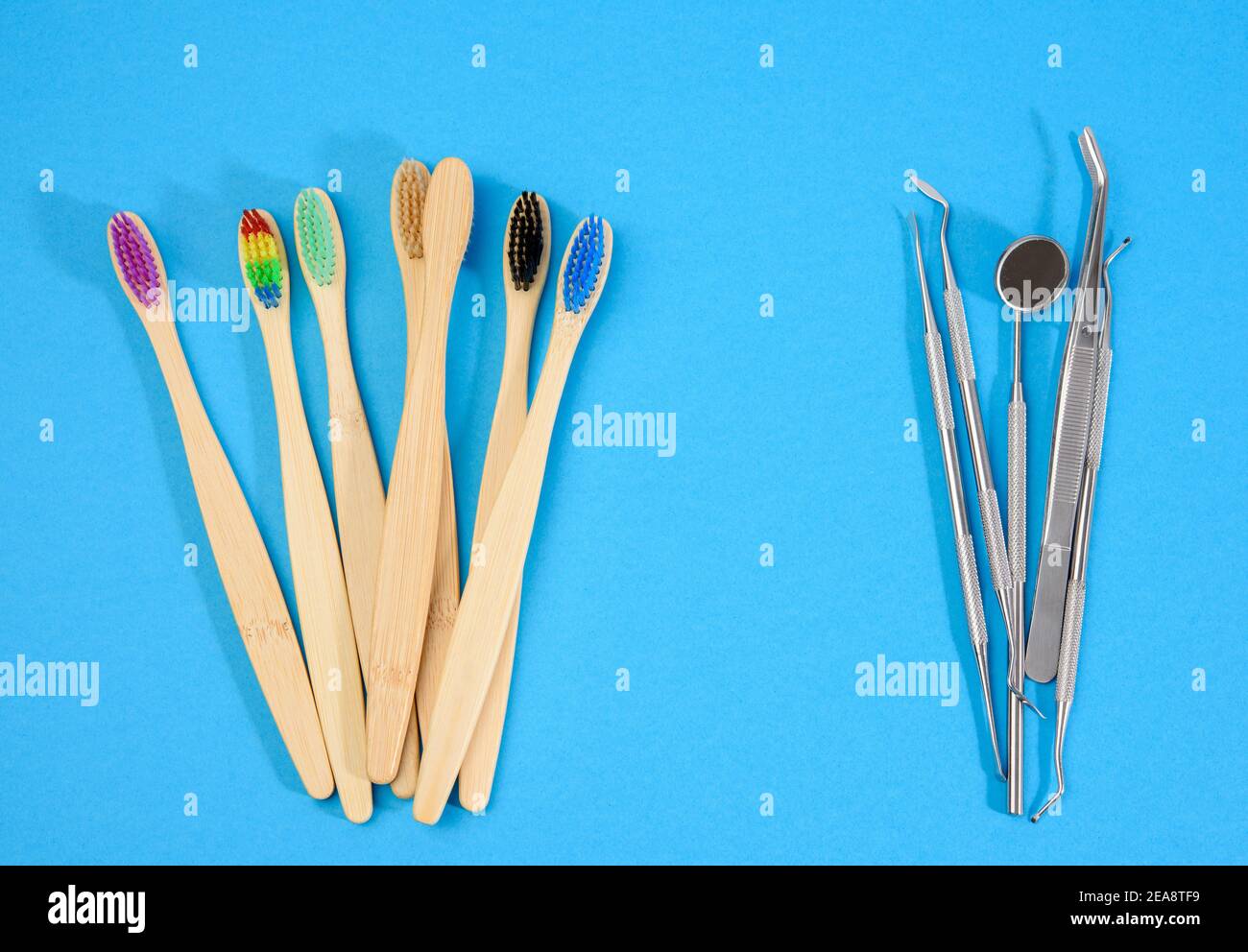 wooden toothbrushes and metal medical items of the dentist on a blue