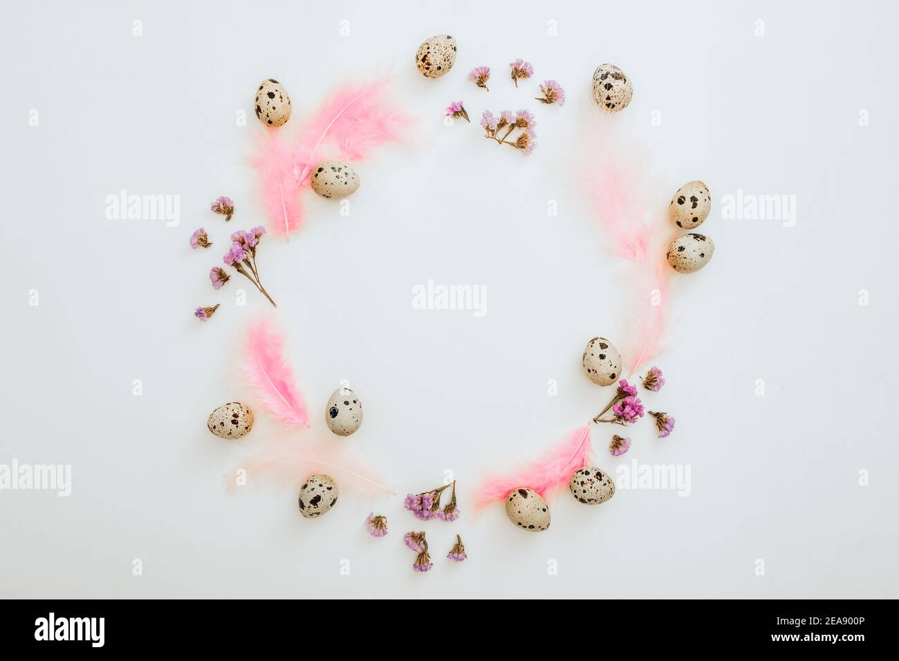 Ester frame composition with quail eggs and pastel feathers on white background. Flat lay, top view Stock Photo