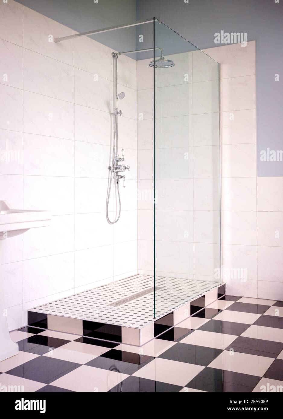 Classic, contemporary living: a double shower in a bathroom finished with black and white floor tiles. Stock Photo