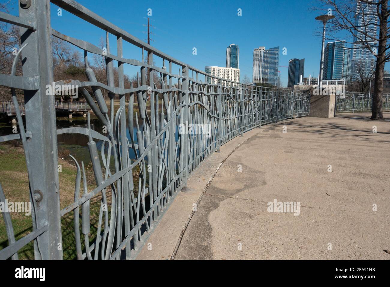 Ornate railing in Butler Metro Park in Austin Texas with skyline in background Stock Photo