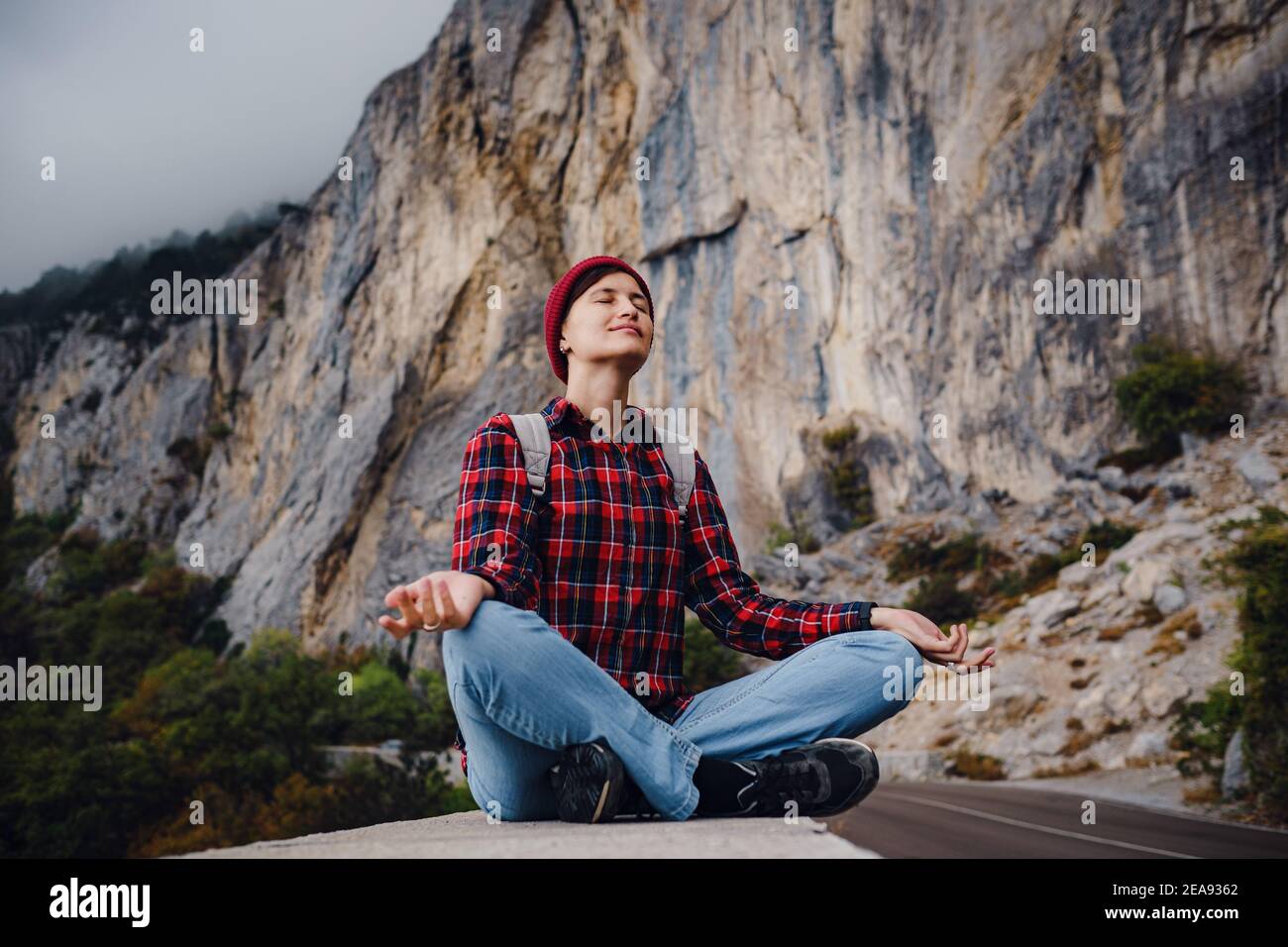 Asian hipster woman walking alone on a mountain highway on an autumn ...