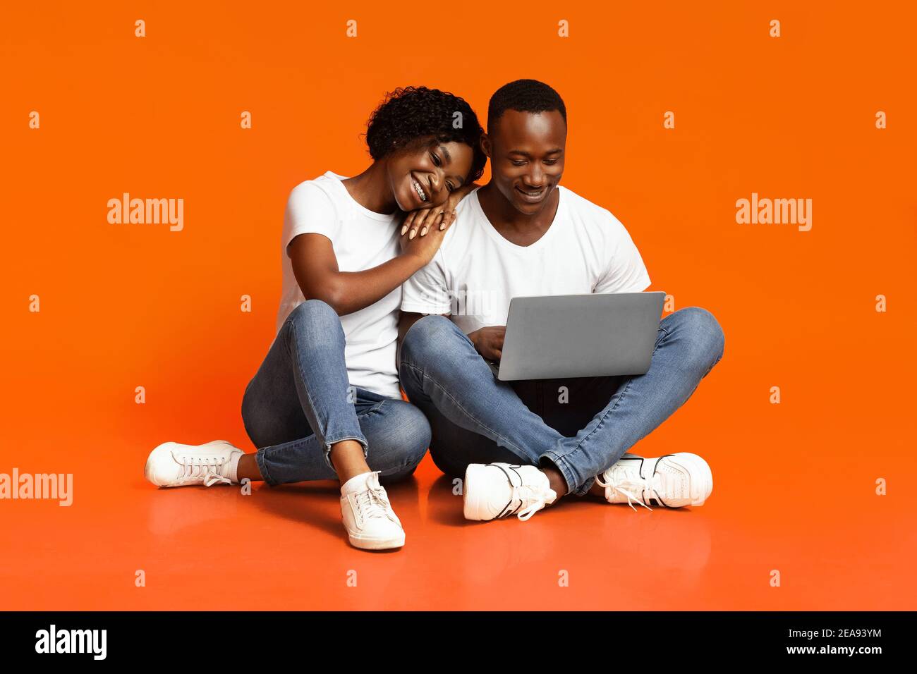 Carefree african american couple using laptop together Stock Photo - Alamy