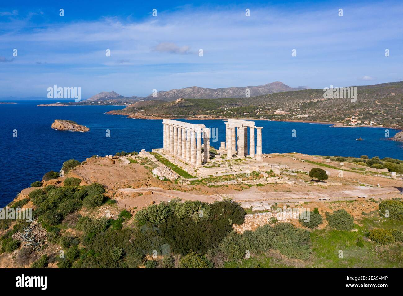 Greece Cape Sounio, Poseidon temple aerial drone view. Archaeological site of ancient greek temple ruins up on a hill, Athens Attica. Cloudy blue sky Stock Photo