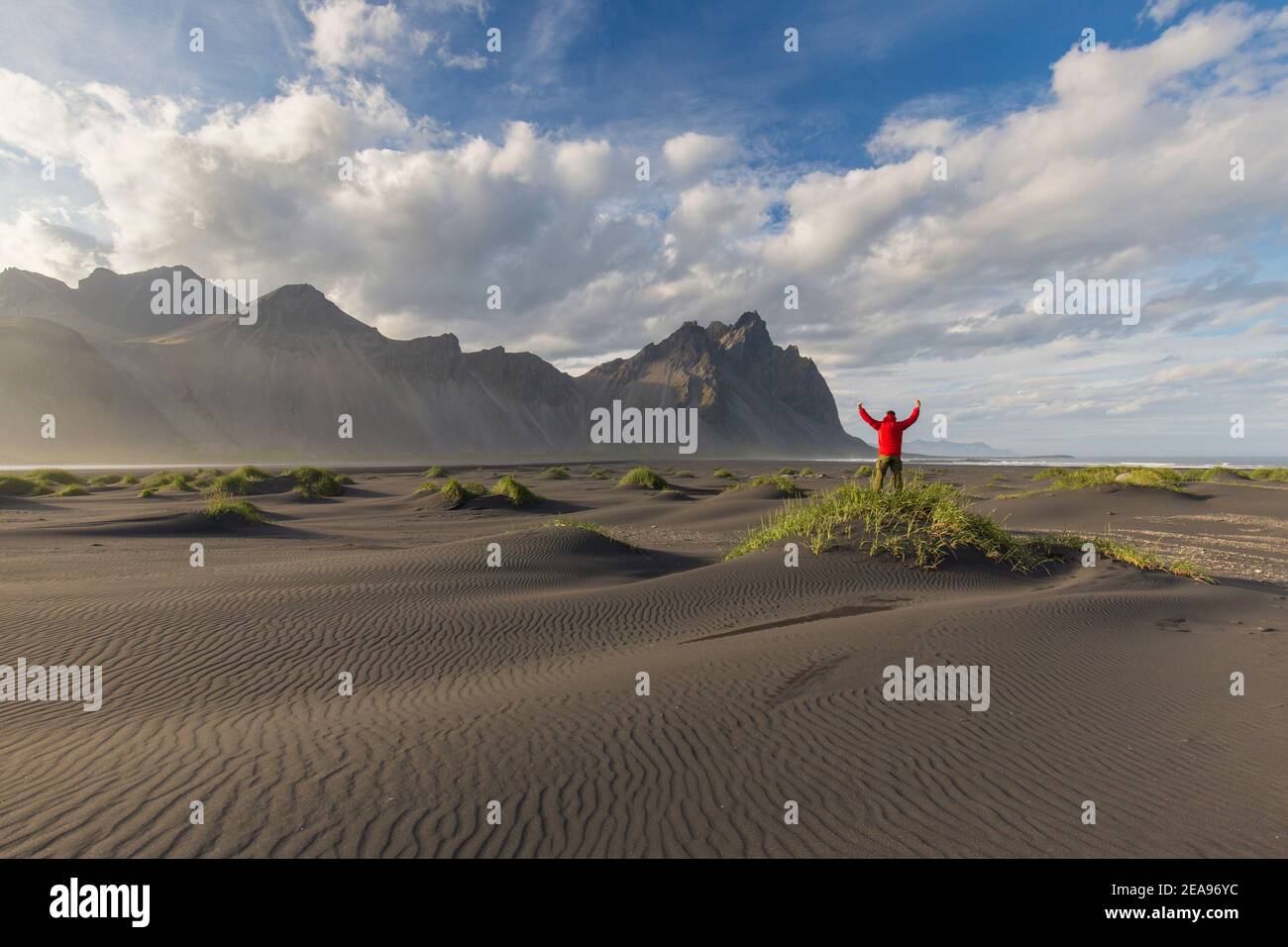 Hiker looking over the Vestrahorn / Vesturhorn, made of gabbro and granophyre rocks, part of the Klifatindur mountain range at Stokksnes, Iceland Stock Photo