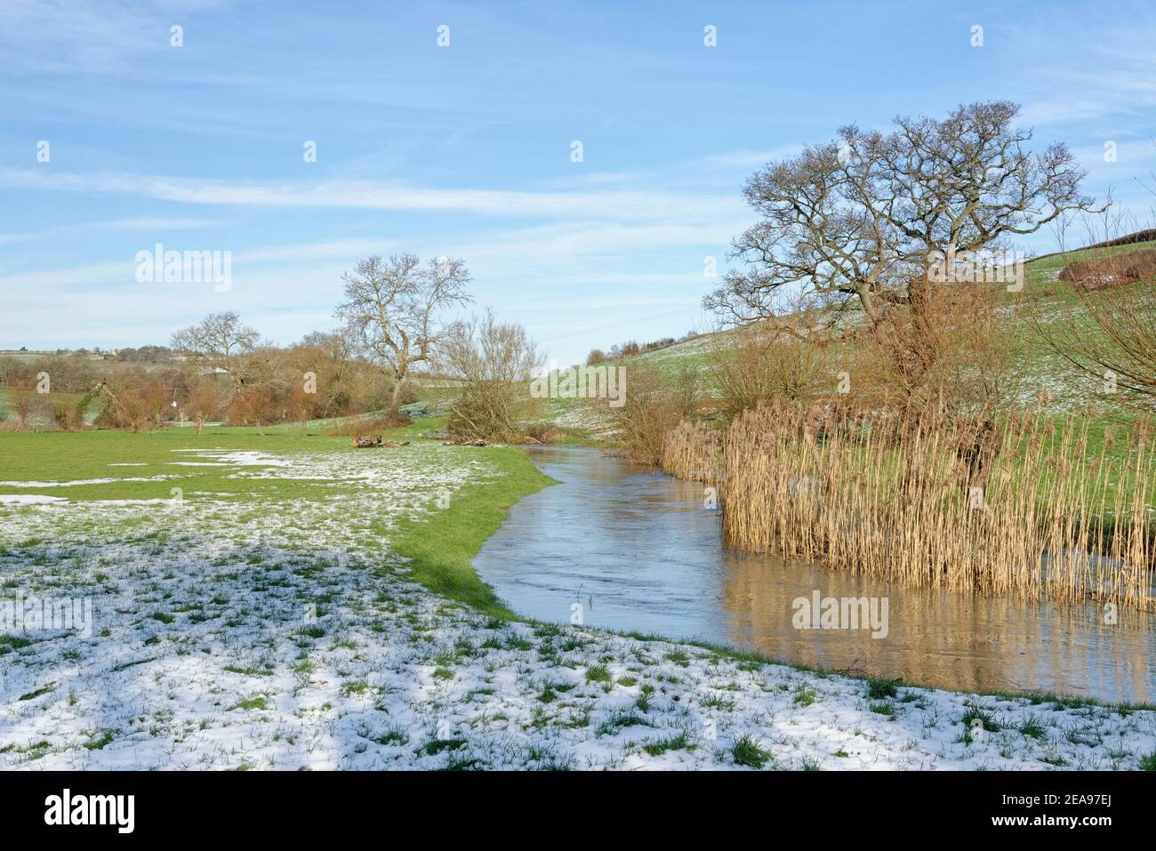 Bybrook River flowing through snow-dusted pastureland, near Box, Wiltshire, UK, January 2021. Stock Photo