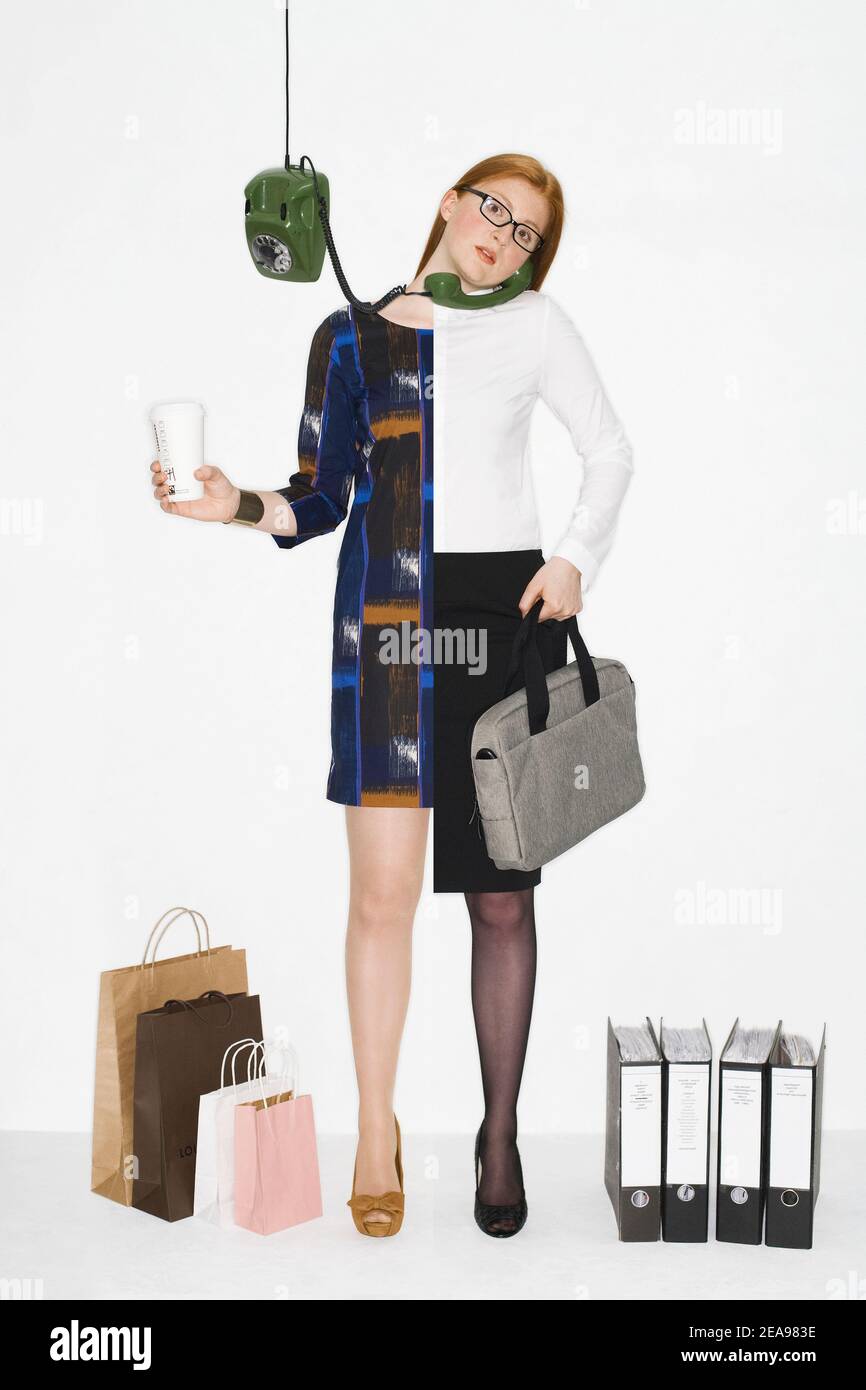 Young woman, red-haired, photo montage, symbolism, white background, green telephone, file folder, shopping bags, laptop bag, drinking glass of glasses, business outfit Stock Photo