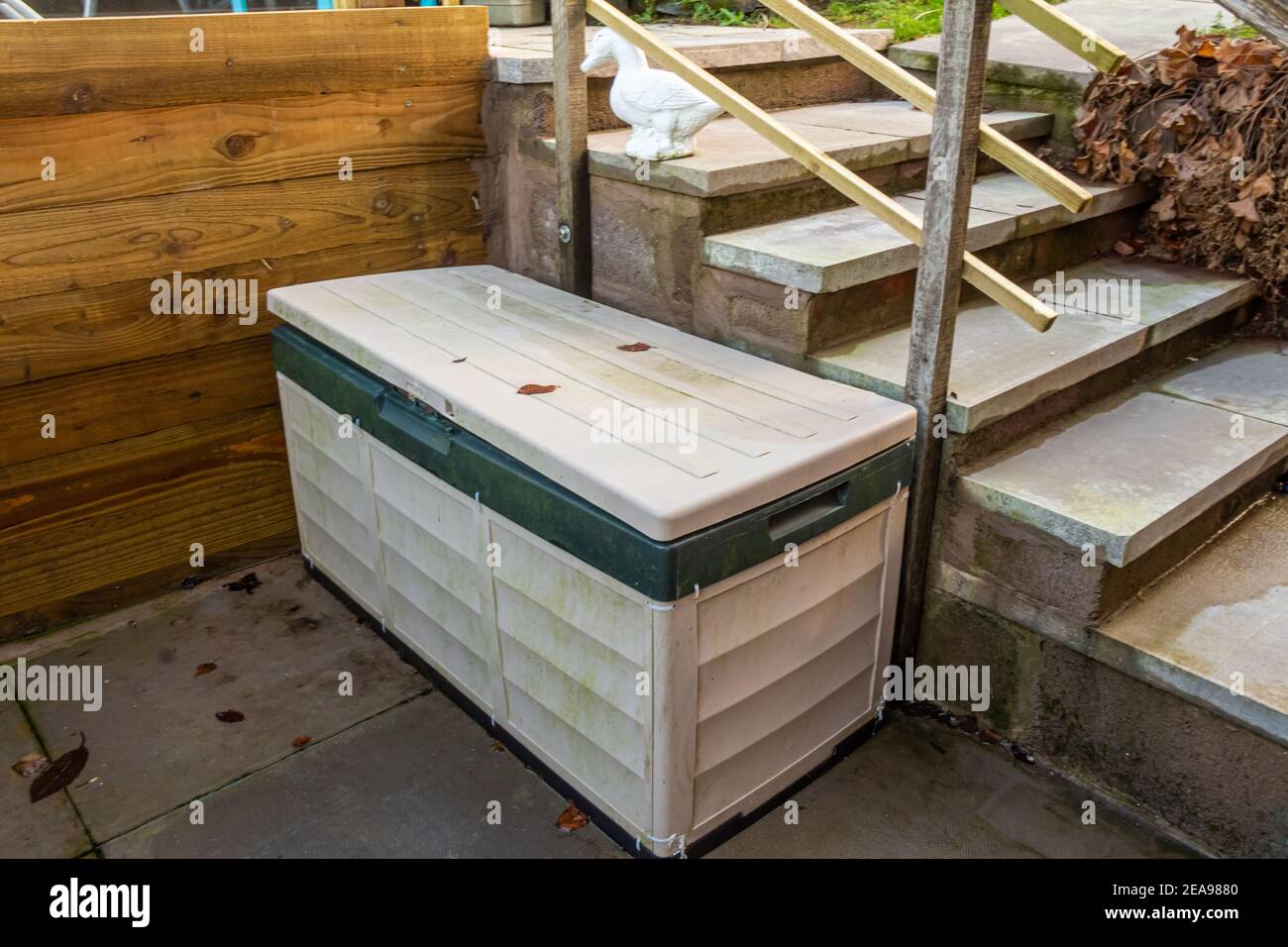 A plastic garden log box beside some steps in a landscaped garden Stock Photo