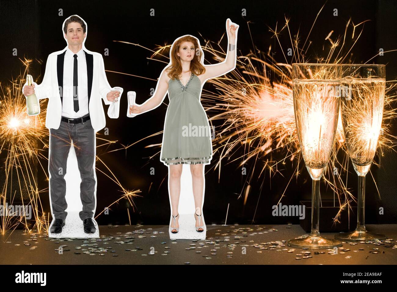 Photo collage, man and woman, in party dress, with champagne glasses, in front of a photo of fireworks, dark background, white jacket, green dress Stock Photo