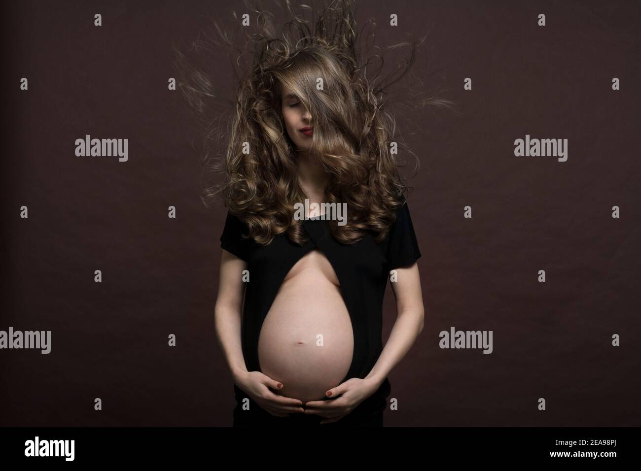 Pregnant woman, wind, blowing hair, studio Stock Photo