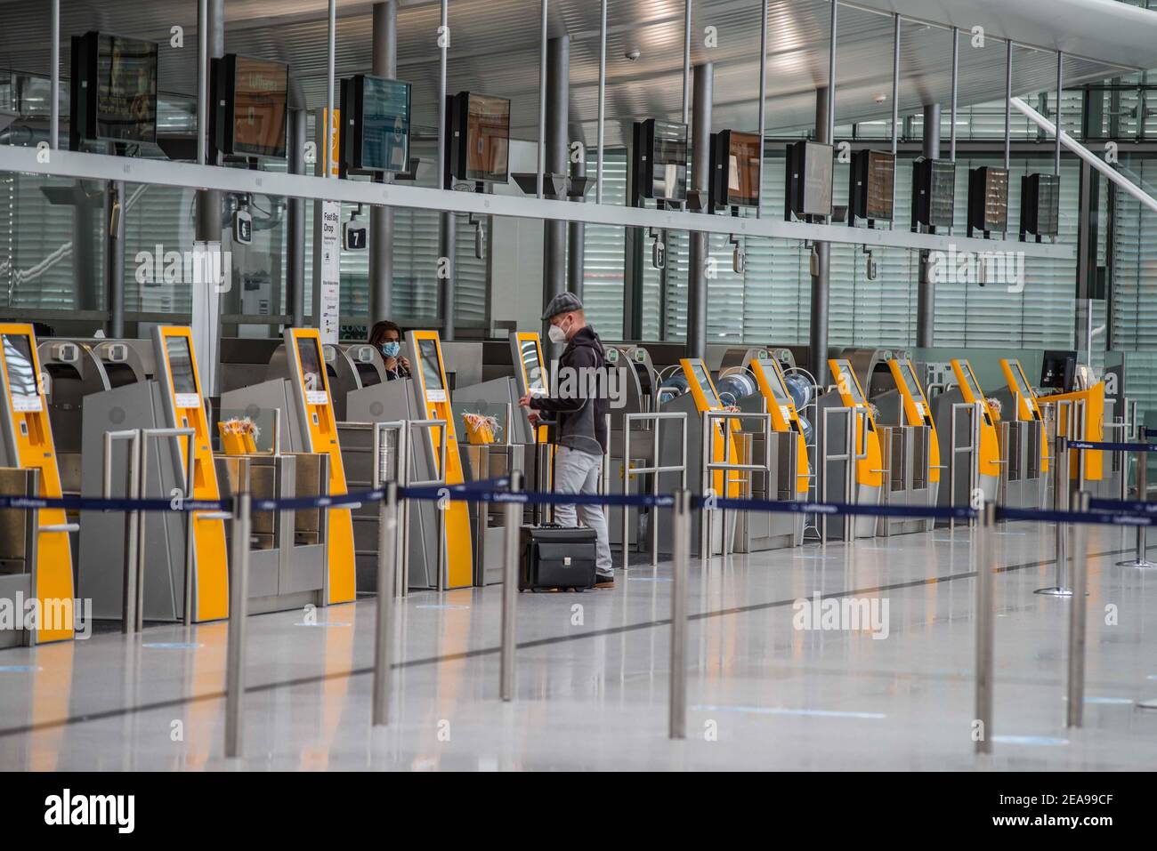 Freising Bei Muenchen, Bavaria, Germany. 8th Feb, 2021. A lone traveler checks in at the usually busy Lufthansa terminal at the Munich International Airport. The Bavarian Interior Ministry in collaboration with the German Federal Police (Bundespolizei) and the Grenzpolizei (Border Police) held a presentation on their roles in fighting the Corona pandemic at airports. Part of the strategy to prevent the importation of the novel Coronavirus, particularly the mutant variants prevalent in South Africa, the United Kingdom, and Brazil involves the DEA Digital Entry Regulation, testing at the ai Stock Photo