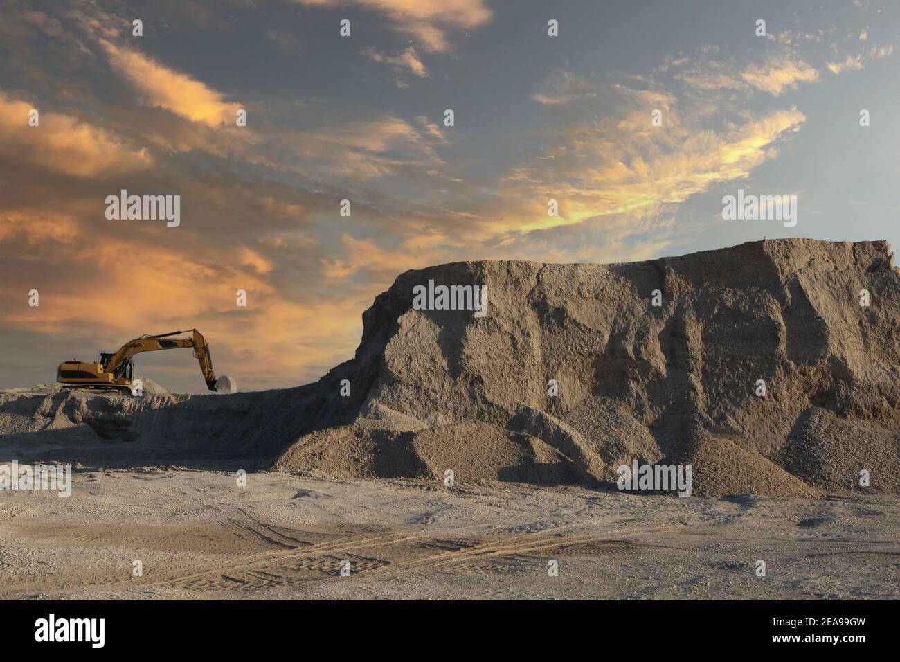 Large excavator working on an industrial site under a sunset sky Stock ...