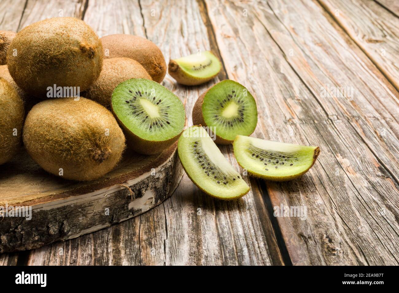 kiwi fruits with slices on wooden table Stock Photo