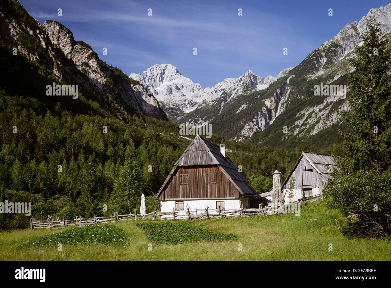 Traditional Trenta stone house with wooden roof and external chimney with mountain background. Stock Photo