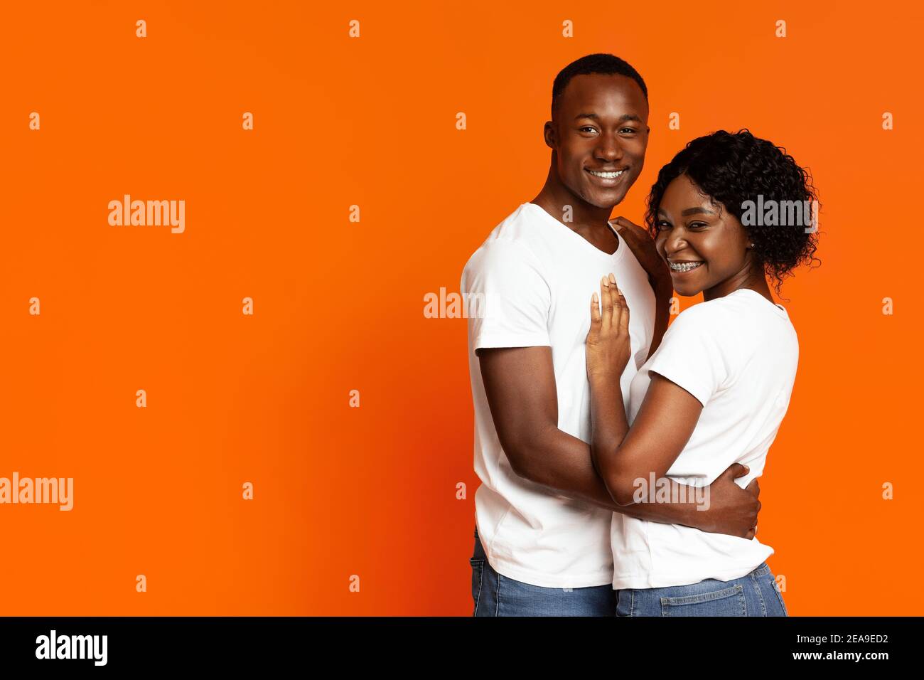 Cute african american couple hugging and smiling at camera Stock Photo ...