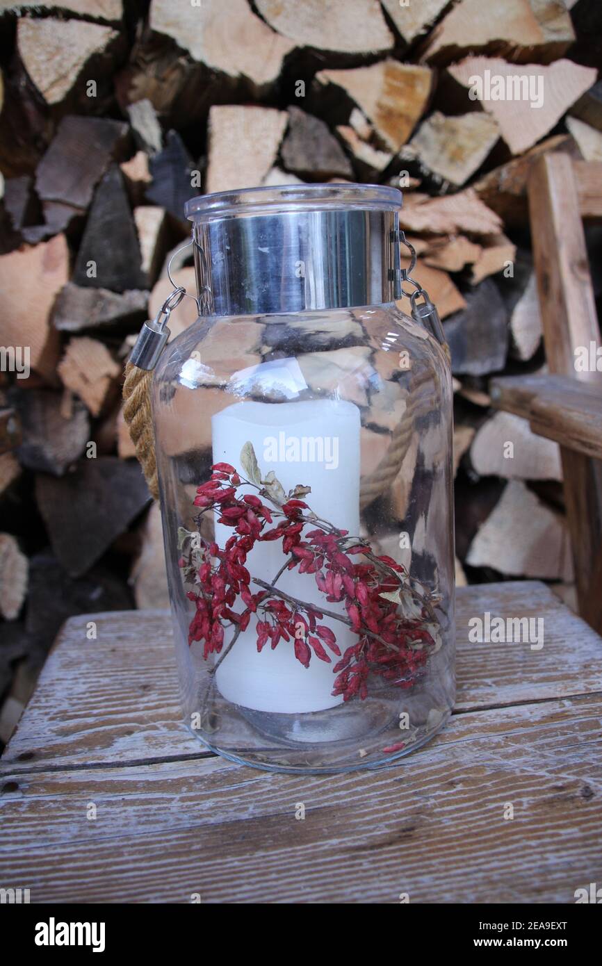 Lantern in front of a pile of wood on a chair, decorative Stock Photo