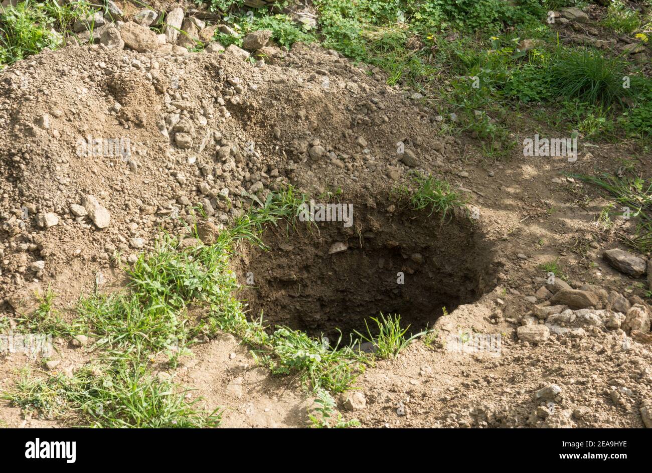 Deep hole in the ground in a garden. Stock Photo