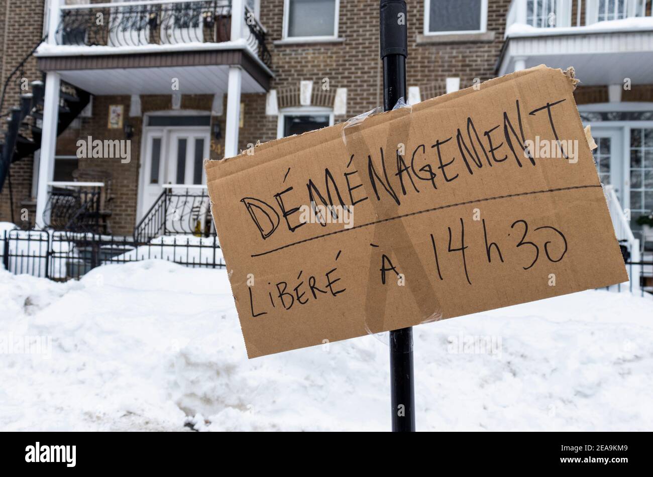 February 6, 2021 - Montreal, Qc, Canada: Moving Day Sign in front of apartments to reserve parking space on a narrow street in winter Stock Photo