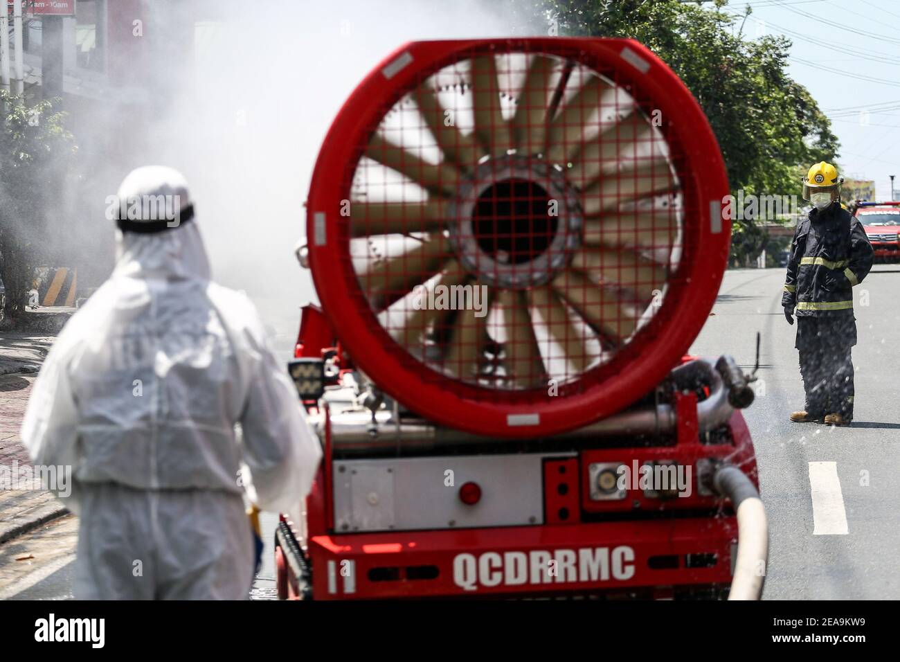 Emergency personnel use a disinfectant spray machine to sanitize a street as a preventive measure against the spread of coronavirus in Manila, Philippines. Stock Photo