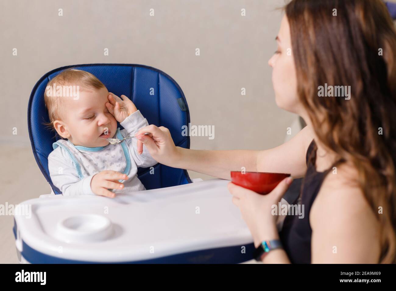 Naughty caucasian infant kid is fussy and refuses to eat Stock Photo