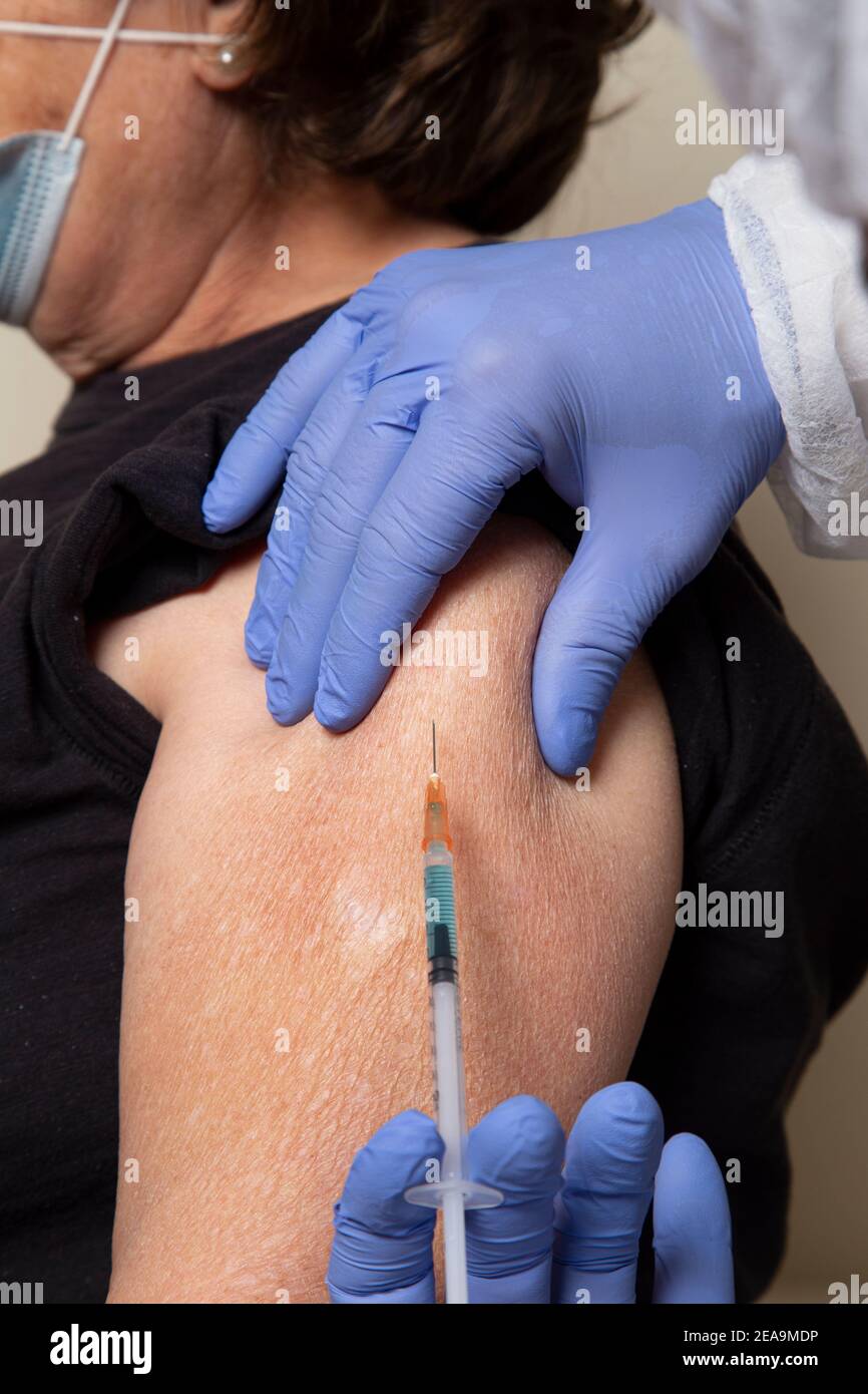 Close up doctor administering shot Stock Photo