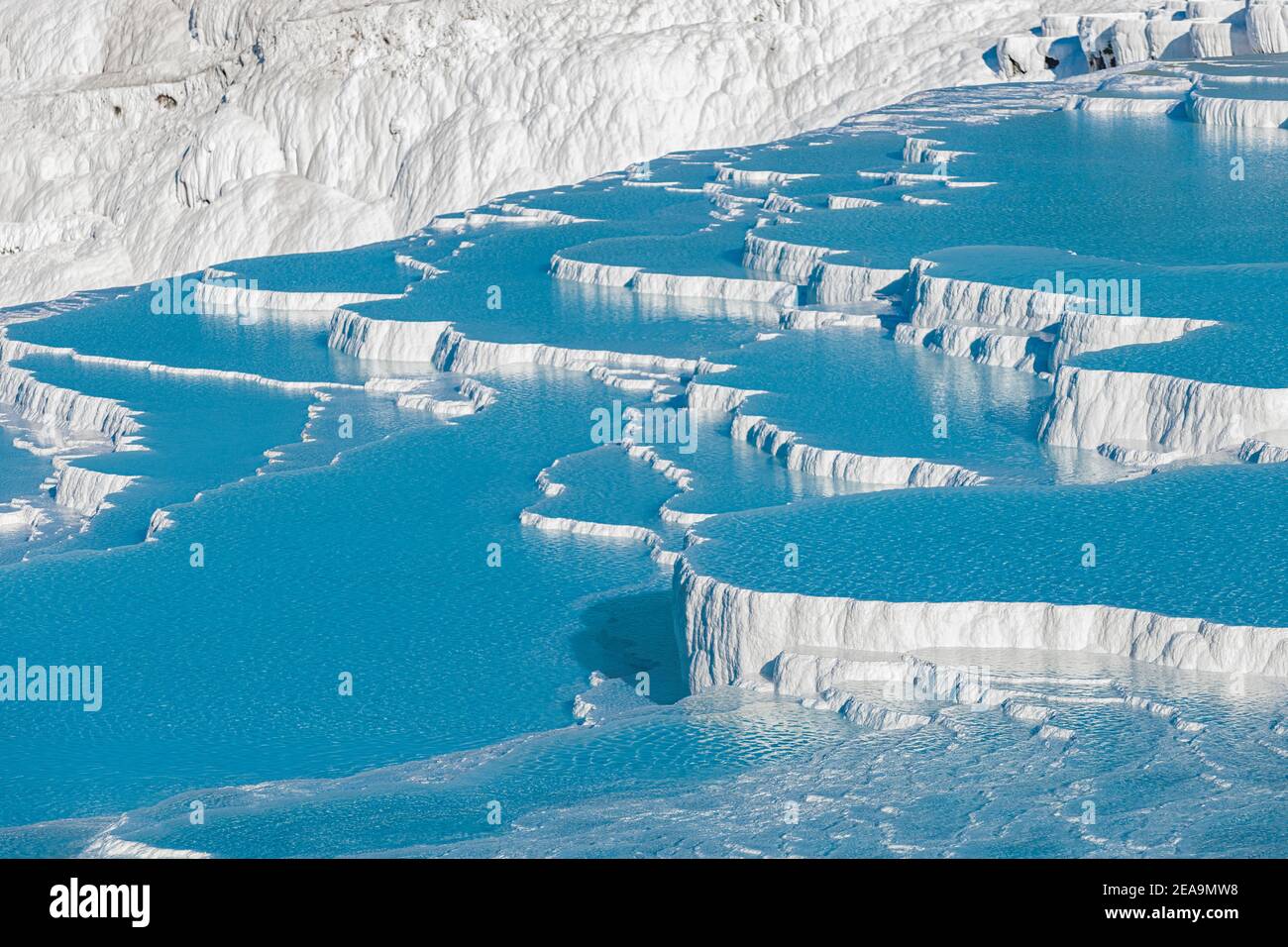 Famous travertines in the Turkish resort of Pamukkale near the city of Denizli. White mineral rock outcrops and thermal water sources. Wonder of natur Stock Photo