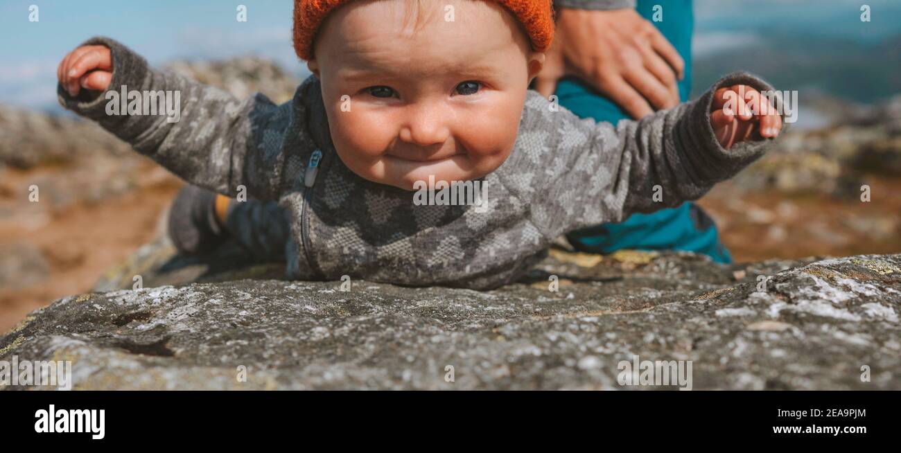 Infant child balancing on rock family travel lifestyle vacation cute baby having fun outdoor Stock Photo