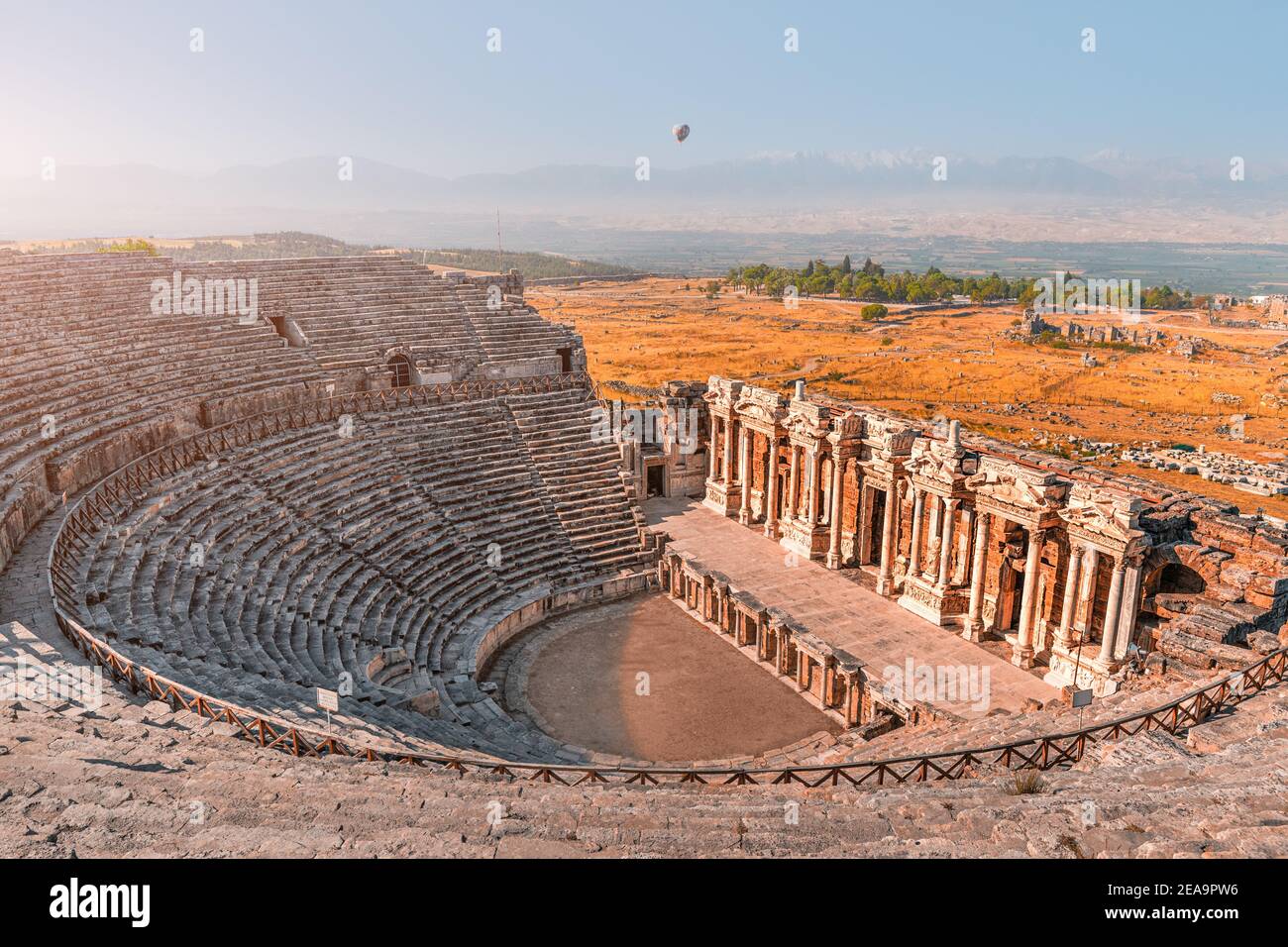 Ancient Greek amphitheater in the city of Hierapolis near Pamukkale in Turkey. Wonders and travel attractions. Hot air balloon above in the morning sk Stock Photo