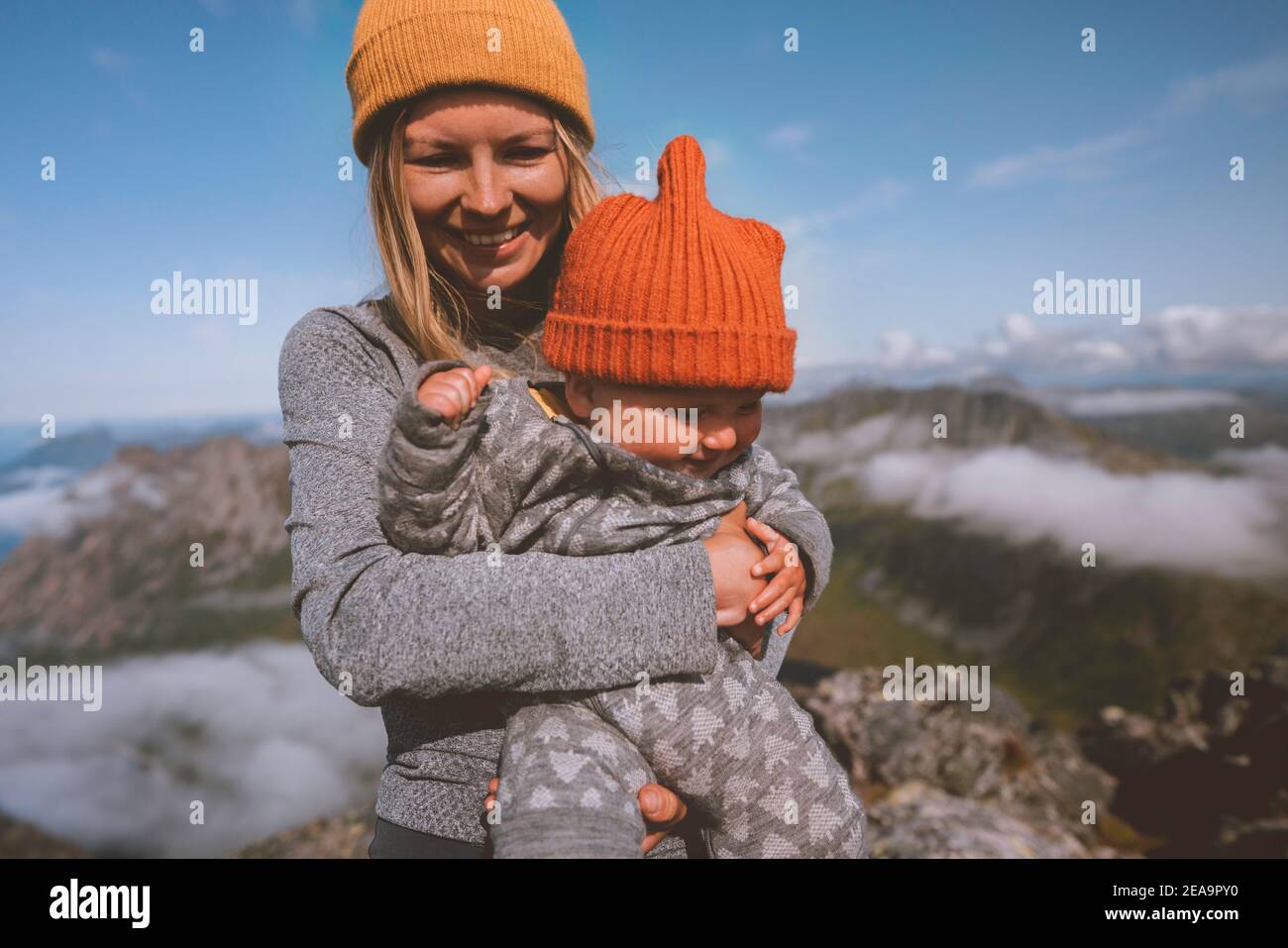 Mother hiking with kid in mountains family traveling outdoor active healthy lifestyle vacation woman with infant child happy emotions Stock Photo