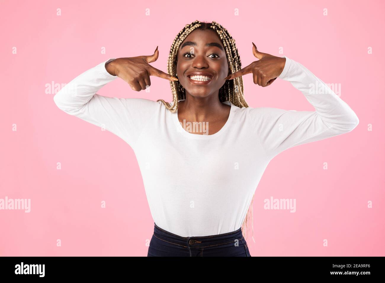 African american woman pointing index fingers at mouth and teeth Stock Photo